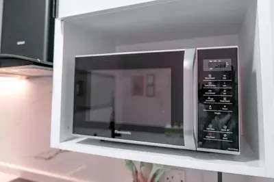 a microwave oven sitting on top of a shelf at StayShort - Stlylish 2 Bedroom in Dubai Marina that Sleeps 4 Near Metro in Dubai