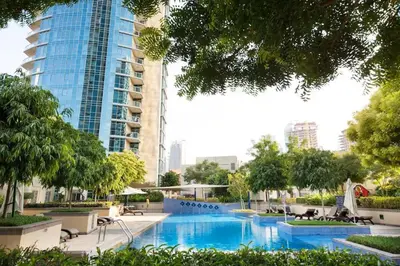 a swimming pool in front of a tall building at Vogue Downtown Burj Residence Near Dubai Mall and Burj Khalifa, Three Bedroom Plus Maid's room Apartment with Balcony and City View, Access to all Amenities in Dubai