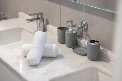 a bathroom counter with a sink and toiletries at Palm Jumeirah Luxury Direct Beach Access and Views in Dubai