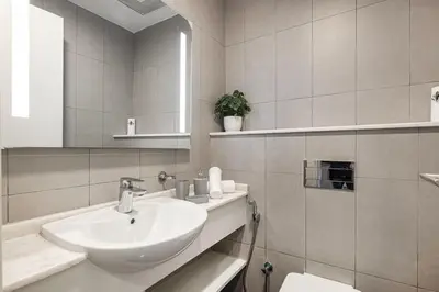 a white bathroom with a sink and a toilet at Palm Jumeirah Luxury Direct Beach Access and Views in Dubai