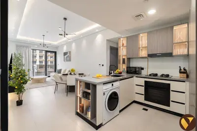 a kitchen and living room with a washer and dryer at Vogue JVC Al Serh Residences Near Circle Mall, One Bedroom Plus Maid's room Apartment with Balcony and City View, Access to all Amenities in Dubai