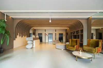 a lobby with chairs and tables in a building at Vogue JVC Al Serh Residences Near Circle Mall, One Bedroom Plus Maid's room Apartment with Balcony and City View, Access to all Amenities in Dubai