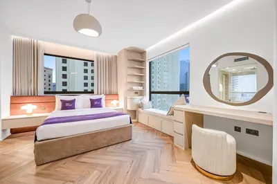 a bedroom with a large bed and a mirror at Modern 1BR JBR Stunning Sea & Ain Dubai Views in Dubai