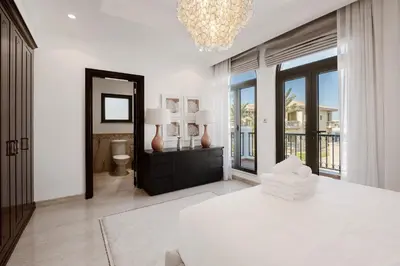 a white bedroom with a bed and a mirror at Maison Privee - Villa on Beach with Private Pool The Palm Jumeirah in Dubai