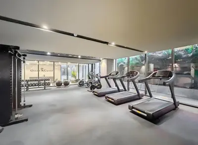 a gym with a row of treadms and elliptical machines at Chic and Peaceful Studio with Balcony & Pool in JVC in Dubai