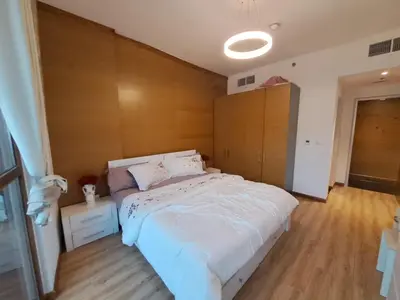 a bedroom with a large white bed and wooden floors at Modern One-Bedroom Apartment King and Queen Beds Two Bathrooms in Dubai