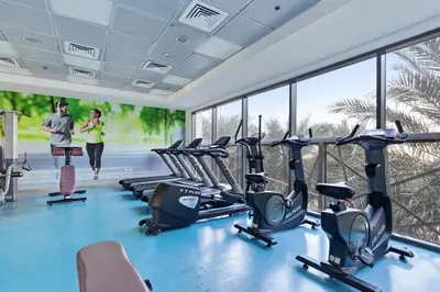 a gym with treadmills and elliptical machines at Safi Apartments 2A, Town Square - 2 Bedroom Apartment - Allsopp & Allsopp in Dubai