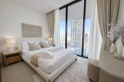 a white bedroom with a bed and a large window at Tranquil 1BR with Private Plunge Pool in Dubai
