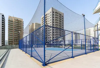 a tennis net with buildings in the background at Tranquil 1BR with Private Plunge Pool in Dubai