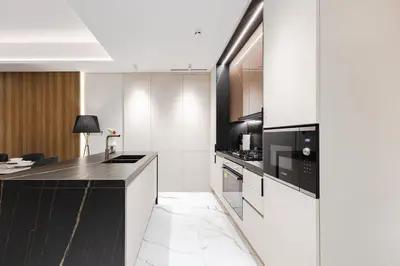 a kitchen with a black and white counter top at Jasmine Lane, JGE - 3 Bedroom with maids' room Townhouse - Allsopp & Allsopp in Dubai