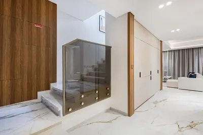 a large glass cabinet in a room with a couch at Jasmine Lane, JGE - 3 Bedroom with maids' room Townhouse - Allsopp & Allsopp in Dubai