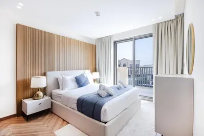 a bedroom with a bed and a large window at Jasmine Lane, JGE - 3 Bedroom with maids' room Townhouse - Allsopp & Allsopp in Dubai