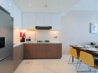 a kitchen and dining room with a table and a microwave at Bright & Spacious 2-Bedroom Apartment Al furjan-706 in Dubai