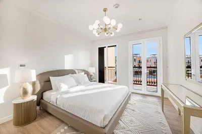 a white bedroom with a bed and a window at Daniels 3BR Villa plus M at La Mer With Beach Access in Dubai