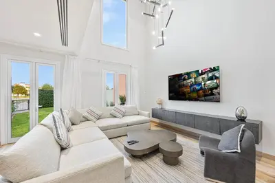 a white living room with a couch and a table at Daniels 3BR Villa plus M at La Mer With Beach Access in Dubai