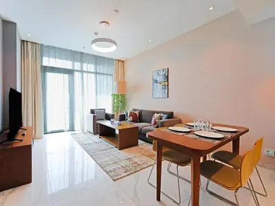 a living room with a table and a couch at Comfortable 2-Bedroom Home in Al Furjan-607 in Dubai