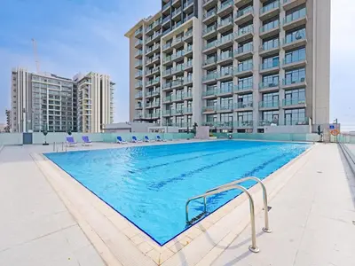 a large swimming pool in front of a building at Comfortable 2-Bedroom Home in Al Furjan-607 in Dubai