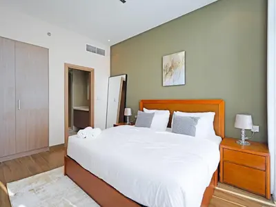 a bedroom with a large bed with white sheets at Elegant 1-Bedroom Apartment in Al Furjan-G01 in Dubai