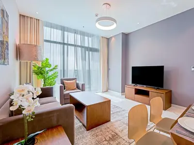 a living room with a couch and a tv at Modern 1-Bedroom Apartment in Sepcoo Residence-1005 in Dubai