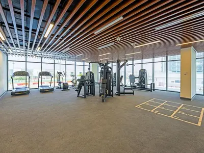 a gym with cardio equipment in a large room with windows at Spacious 2-Bedroom Apartment Al Furjan-104 in Dubai