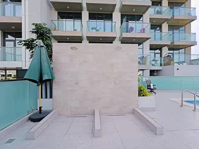 a building with a green umbrella in a courtyard at Spacious 2-Bedroom Apartment Al Furjan-104 in Dubai
