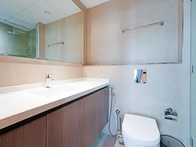 a bathroom with a sink and a toilet and a mirror at Spacious 2-Bedroom Apartment in Al Furjan-1010 in Dubai