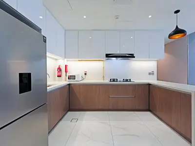 a kitchen with white and brown cabinets and a microwave at Well-Maintained 2-Bedroom Home in Community-410 in Dubai