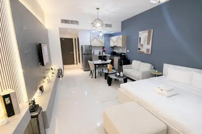 a living room with a white couch and a dining room at Extra-Large Studio l AG Tower l Business Bay in Dubai
