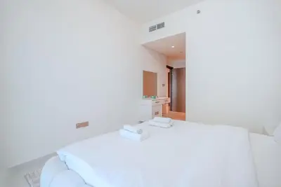 a white room with a bed and a mirror at TRPS - Grand Bleu Tower 2, EMAAR Beachfront - Atlantis & Marina View, Private Beach, Furnished in Dubai