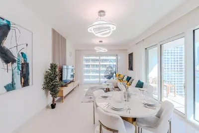 a white living room with a table and chairs at TRPS - Grand Bleu Tower 2, EMAAR Beachfront - Atlantis & Marina View, Private Beach, Furnished in Dubai