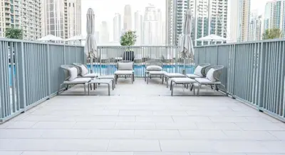 a row of chairs and tables on a balcony at Brand New & Welcoming 2BDR In Forte Downtown 34 in Dubai