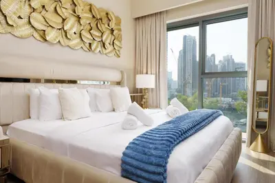 a bedroom with a large bed and a large window at Burj Royale Collection by The Luxe Manor - Downtown Dubai in Dubai