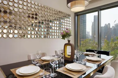 a dining room with a table with plates and wine glasses at Burj Royale Collection by The Luxe Manor - Downtown Dubai in Dubai
