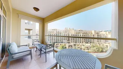 a balcony with a table and chairs and a large window at Vacationer l 1 Bed on The Palm l City Views l Near Atlantis in Dubai