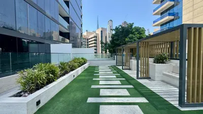 an internal courtyard of a building with grass and plants at Cozy Studio with Balcony and Jacuzzi I Near Dubai Mall & Downtown I Sleeps 4 in Dubai
