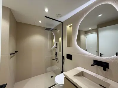a bathroom with a sink and a shower with a mirror at High End Upgraded 1BR Living in The Greens in Dubai
