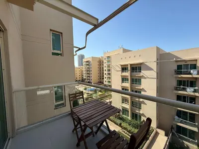 a balcony with two chairs and a wooden table at High End Upgraded 1BR Living in The Greens in Dubai
