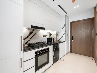 a kitchen with a stove and a microwave at Amazing Studio with Balcony and Jacuzzi I Near Dubai Mall & Downtown I Sleeps 4 in Dubai