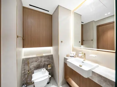 a bathroom with a toilet and a sink and a mirror at Amazing Studio with Balcony and Jacuzzi I Near Dubai Mall & Downtown I Sleeps 4 in Dubai