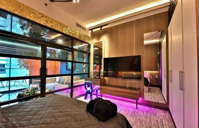 a bedroom with a large bed and a tv at The Eden Suite Modern Luxury Meets Cozy Comfort in Dubai