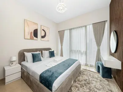 a bedroom with a bed and a sink and a window at EMAAR GRANDE - Cozy 1 Bedroom Apartment - Infinity Pool - 1min to Dubai Mall and Burj Khalifa in Dubai