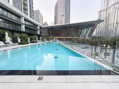 a large swimming pool in a building with tall buildings at EMAAR GRANDE - Cozy 1 Bedroom Apartment - Infinity Pool - 1min to Dubai Mall and Burj Khalifa in Dubai