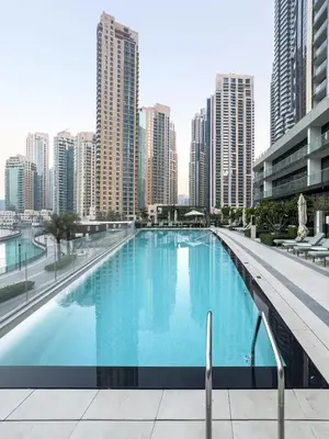 a large swimming pool in a city with tall buildings at EMAAR GRANDE - Cozy 1 Bedroom Apartment - Infinity Pool - 1min to Dubai Mall and Burj Khalifa in Dubai
