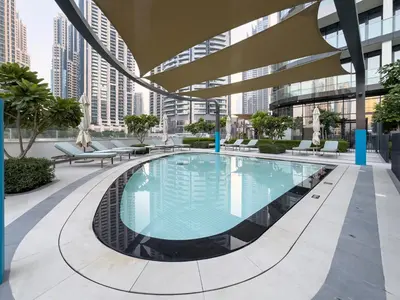 a large swimming pool in a building with tall buildings at EMAAR GRANDE - Cozy 1 Bedroom Apartment - Infinity Pool - 1min to Dubai Mall and Burj Khalifa in Dubai