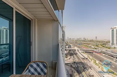 a balcony of a building with a view of a city at Elegant 1BR l Steps to Metro l Free Parking in Dubai