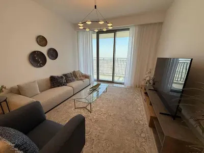 a living room with a couch and a flat screen tv at 17 Icon Bay Creek Harbour in Dubai
