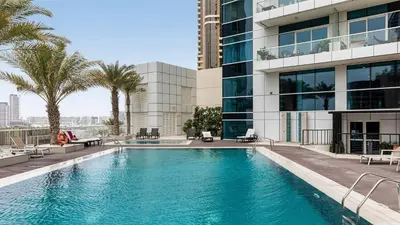 a swimming pool in front of a building with palm trees at Penthouse with panoramic water-view Ultra-luxury in Dubai