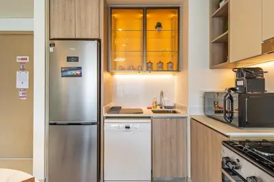 a kitchen with a stainless steel refrigerator and cabinets at Superhost - 1BR Apartment , Pool & Gym , Near Dubai Hills Mall in Dubai