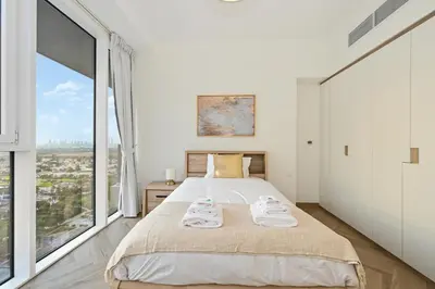 a bedroom with a bed and a large window at Bloomfields Luxurious 3BR in West Residences in Dubai