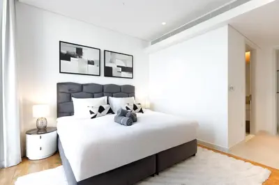a white bedroom with a large bed with white walls at Luxury 2BR with Sea, Ain Dubai & Skyline Views in Dubai